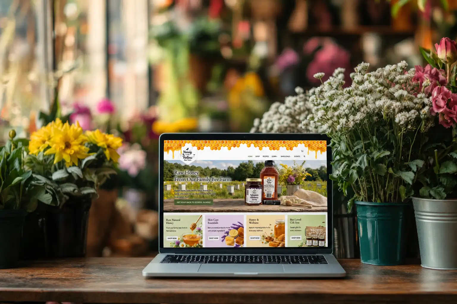 Honey in the hollow website on screen surrounded by flowers